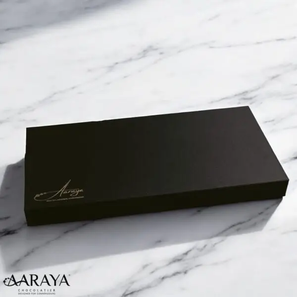 An exquisite assortment of Assorted Luxury Dates by Aaraya Chocolates, showcasing a symphony of premium flavors including Lemon Peel, Pistachio, Orange Peel, Cashew Nut, Salted Hazelnut, Feuilletine Crunch, Walnut, Almond Blanched, and Pistachio Ganache. Each date is a masterpiece of indulgence, promising a sensory journey through the finest gourmet fillings.