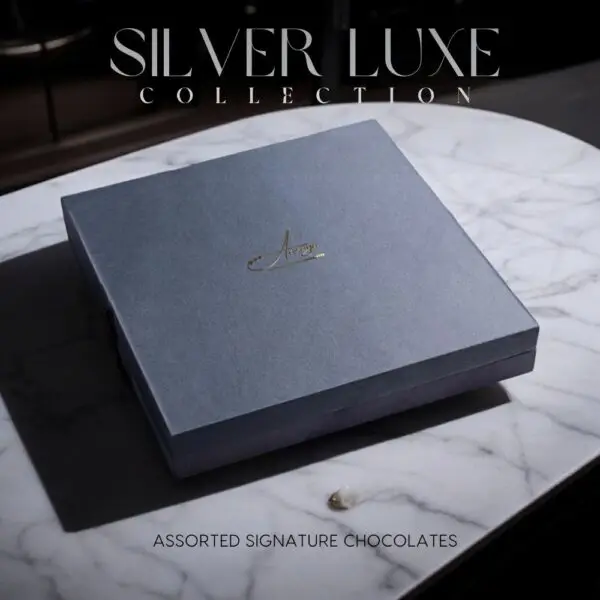 Discover the AARAYA® Assorted Chocolates Box - Silver Luxe Collection, a luxurious selection of handcrafted chocolates in an elegant silver satin box. Perfect for gifting or indulging in premium chocolate bliss.