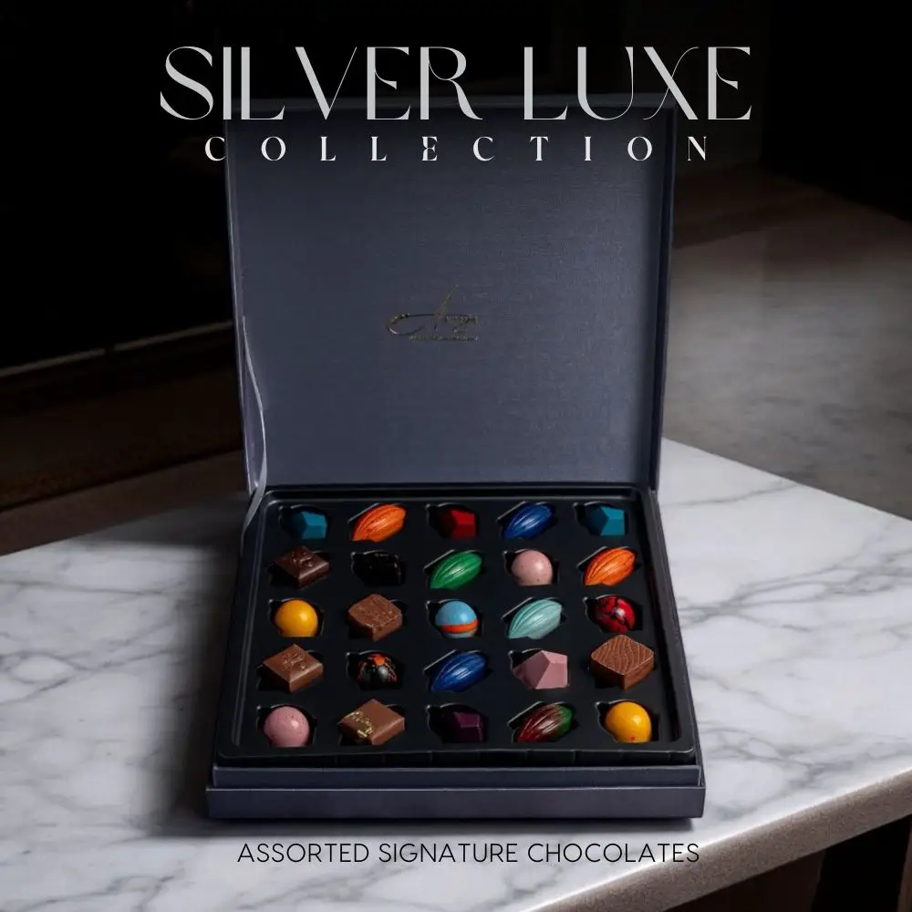 Discover the AARAYA® Assorted Chocolates Box - Silver Luxe Collection, a luxurious selection of handcrafted chocolates in an elegant silver satin box. Perfect for gifting or indulging in premium chocolate bliss.