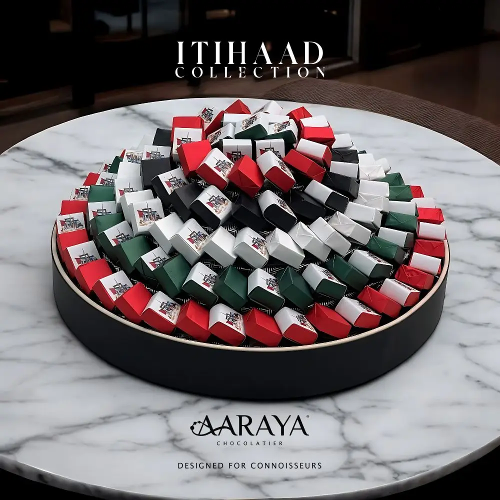 Luxurious NATIONAL DAY ITIHAAD Collection by AARAYA® Chocolatier for UAE National Day, featuring 146 handcrafted premium chocolates in a striking 39 cm display, celebrating unity, heritage, and pride. Total weight of 2.6 kg, including 1.7 kg of artisanal chocolates. Available for AED 1,199.