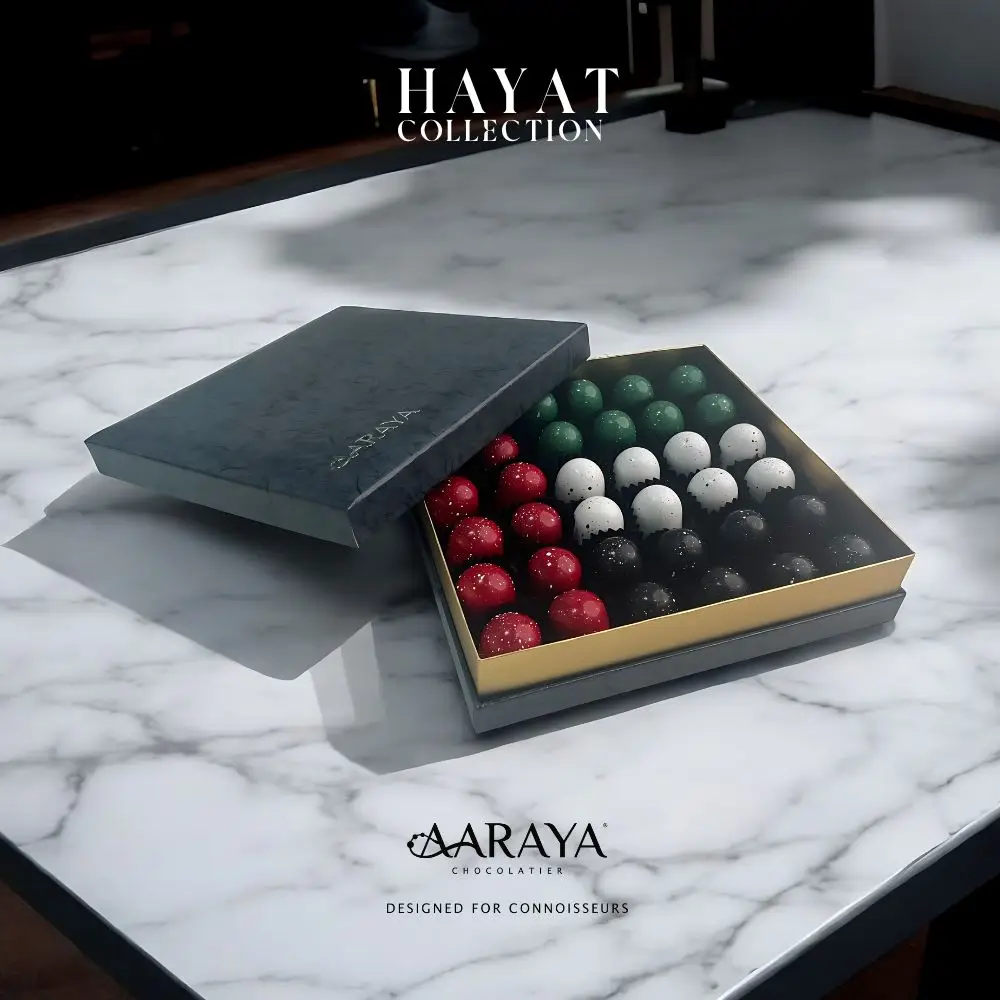 Luxurious HAYAT Collection by AARAYA® Chocolatier for UAE National Day, symbolizing life, growth, and unity. Featuring 36 handcrafted premium chocolates in a refined 20 cm x 20 cm box, with a total weight of 700 grams, including 500 grams of artisanal chocolates. Celebrating tradition and luxury. Available for AED 399.