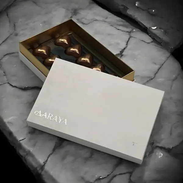 Pearl Valentines Golden Heart Collection by AARAYA®, featuring 10 handcrafted golden heart-shaped plain milk chocolates in a sleek pearl white box.